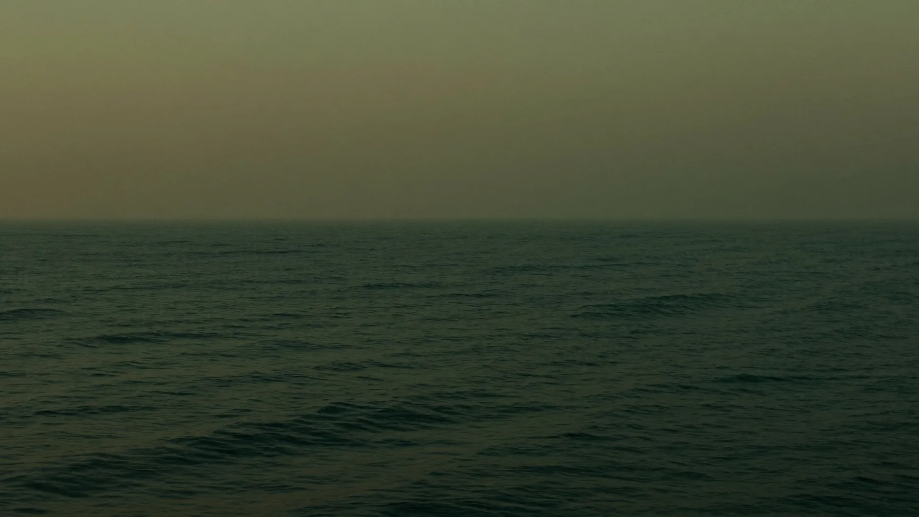 Mare aperto calmo all'alba con orizzonte in foschia
